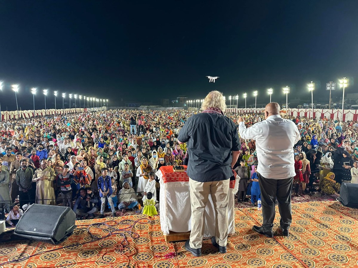 Speakers addressing a large outdoor ministry gathering